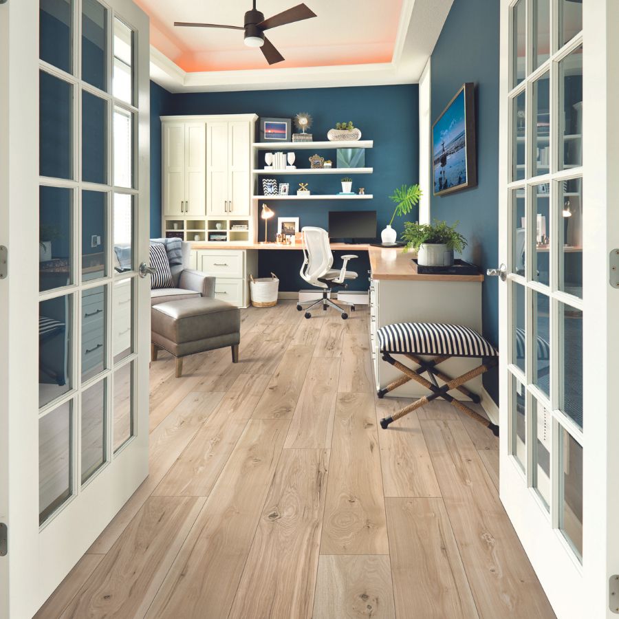 Laminate flooring in home office, blue walls, desk, white chair